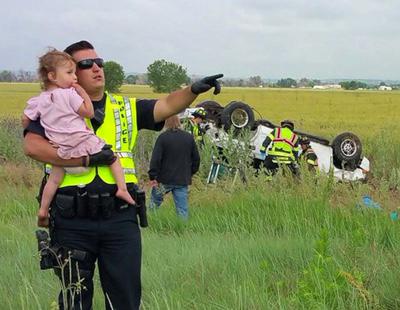 Un policía consuela a una niña después de perder a su padre en un accidente de tráfico