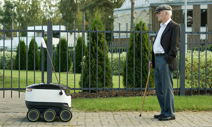 Uno de los robots repartidores ante un anciano