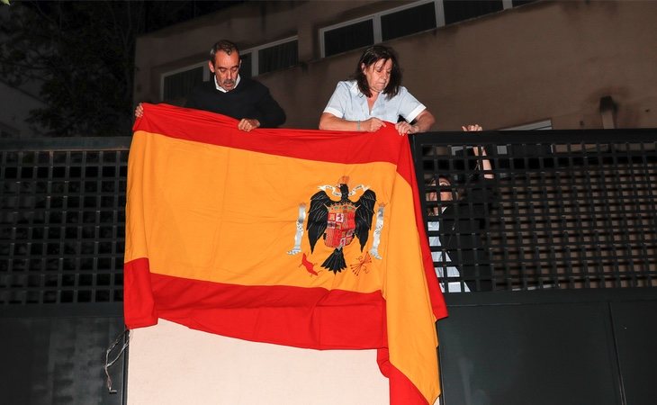 La empleada del hogar de Francis Franco, nieto del dictador, cuelga una bandera preconstitucional en la fachada de su vivienda