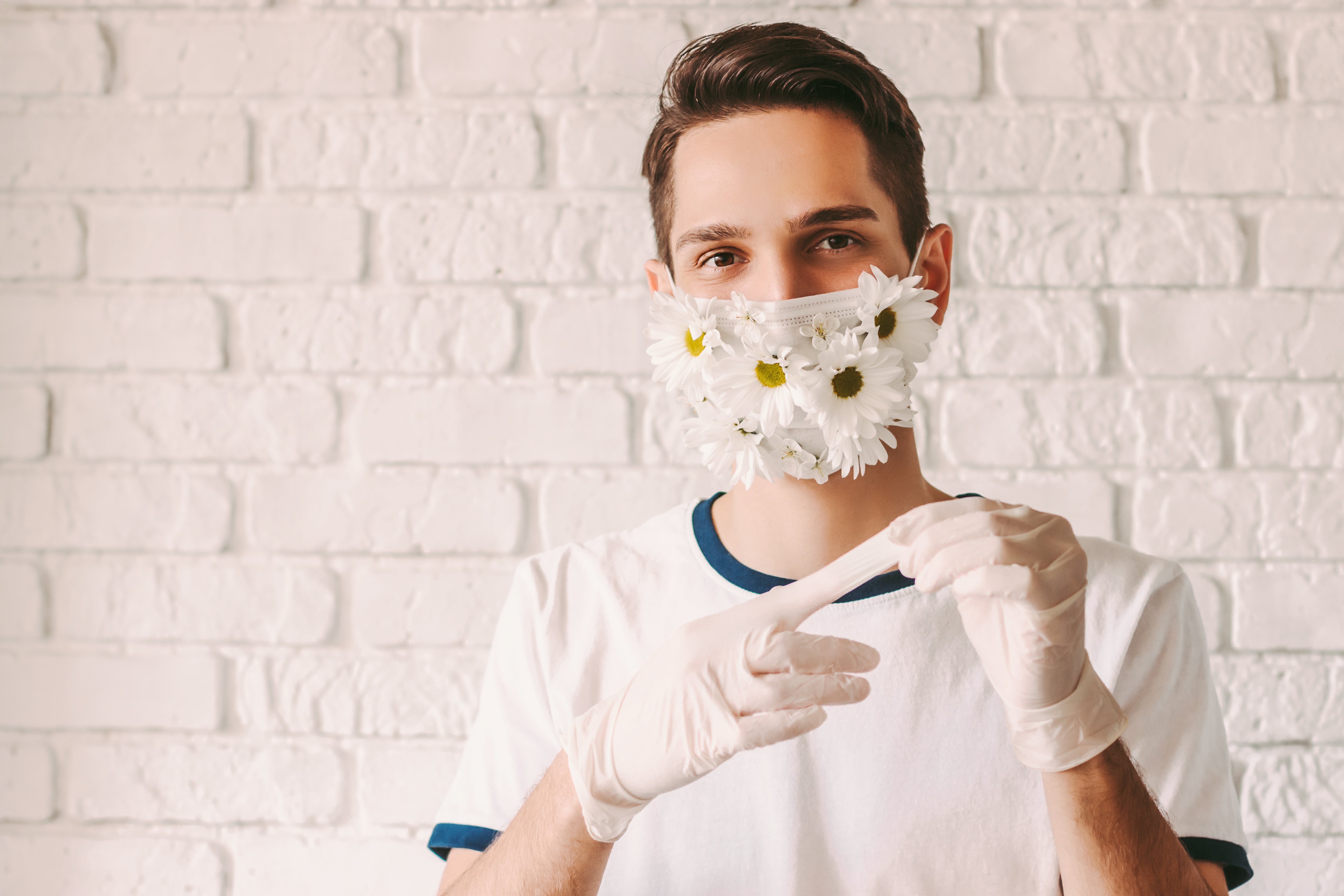 Médico masculino feliz retrato en verano máscara protectora de cara quitando guantes médicos estériles.