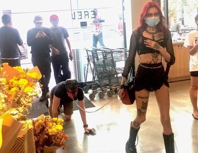 Una dominatrix pasea por un hombre con correa y careta de perro por un supermercado