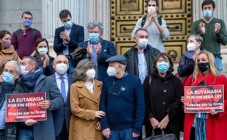 La exministra socialista María Luisa Carcedo, impulsora de la Ley de la Eutanasia, con familiares, activistas y varios diputados, frente al Congreso tras la aprobación