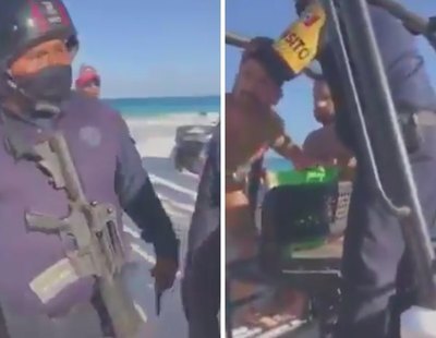 Dos policías con ametralladoras detienen a una pareja gay por besarse en una playa de México