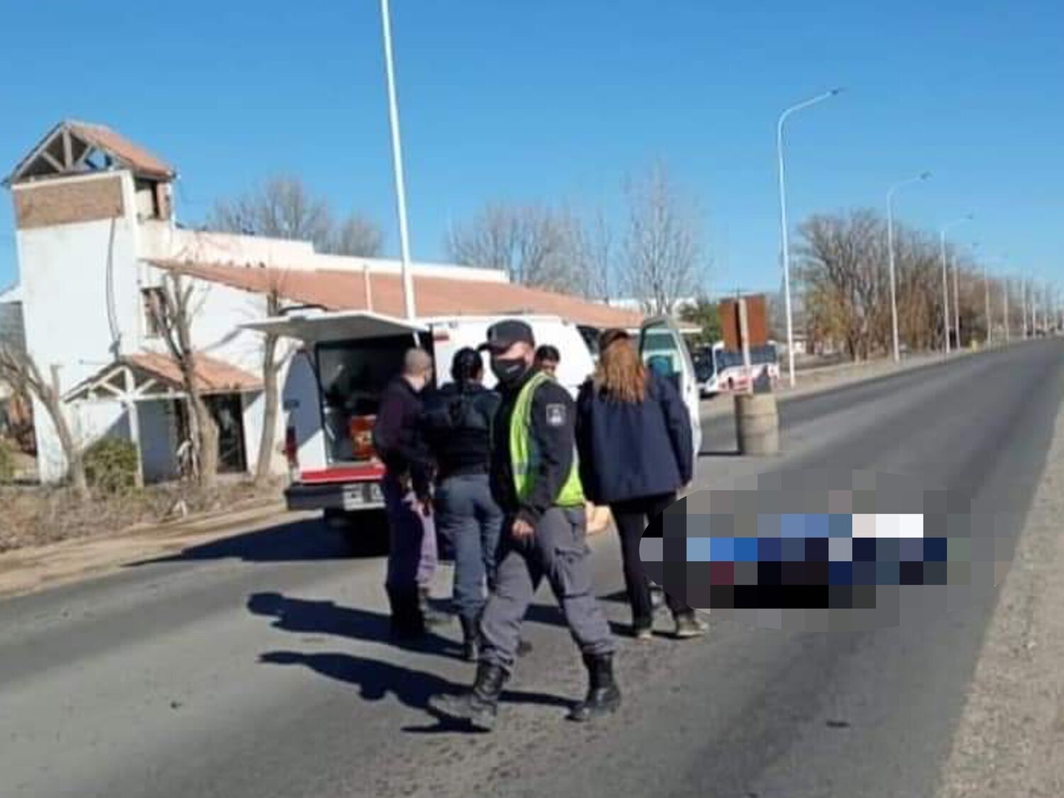 Un ataúd cae a la carretera desde el coche fúnebre, se abre y cae el cuerpo sobre el asfalto