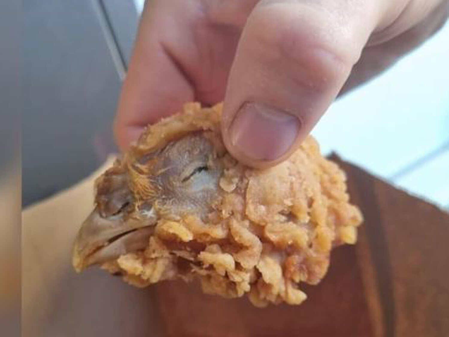 Compra una alitas en KFC y encuentra una cabeza de pollo, con ojos y pico, incrustados en una masa de rebozado