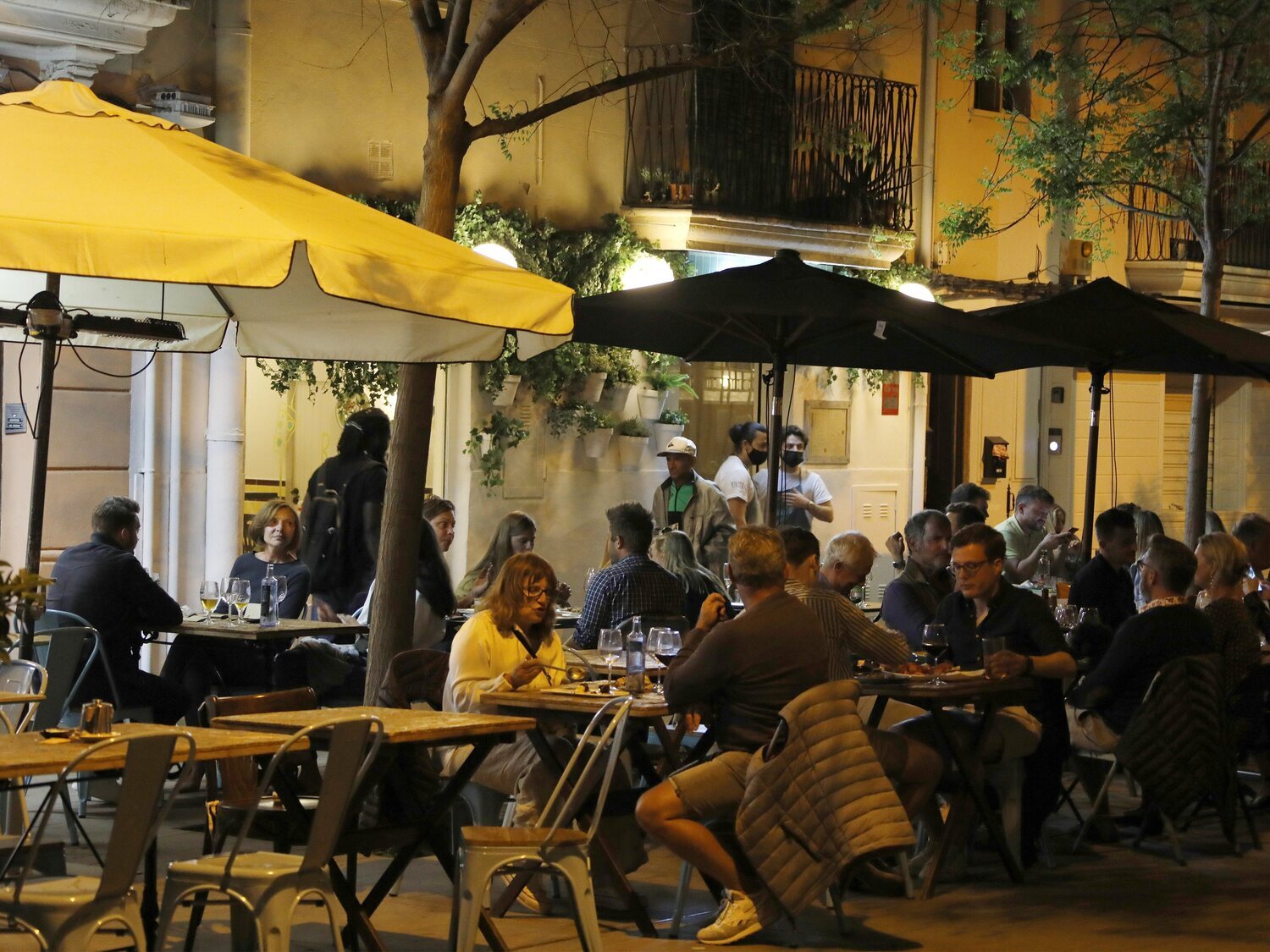 Un bar monta su terraza encima de un coche aparcado en la acera