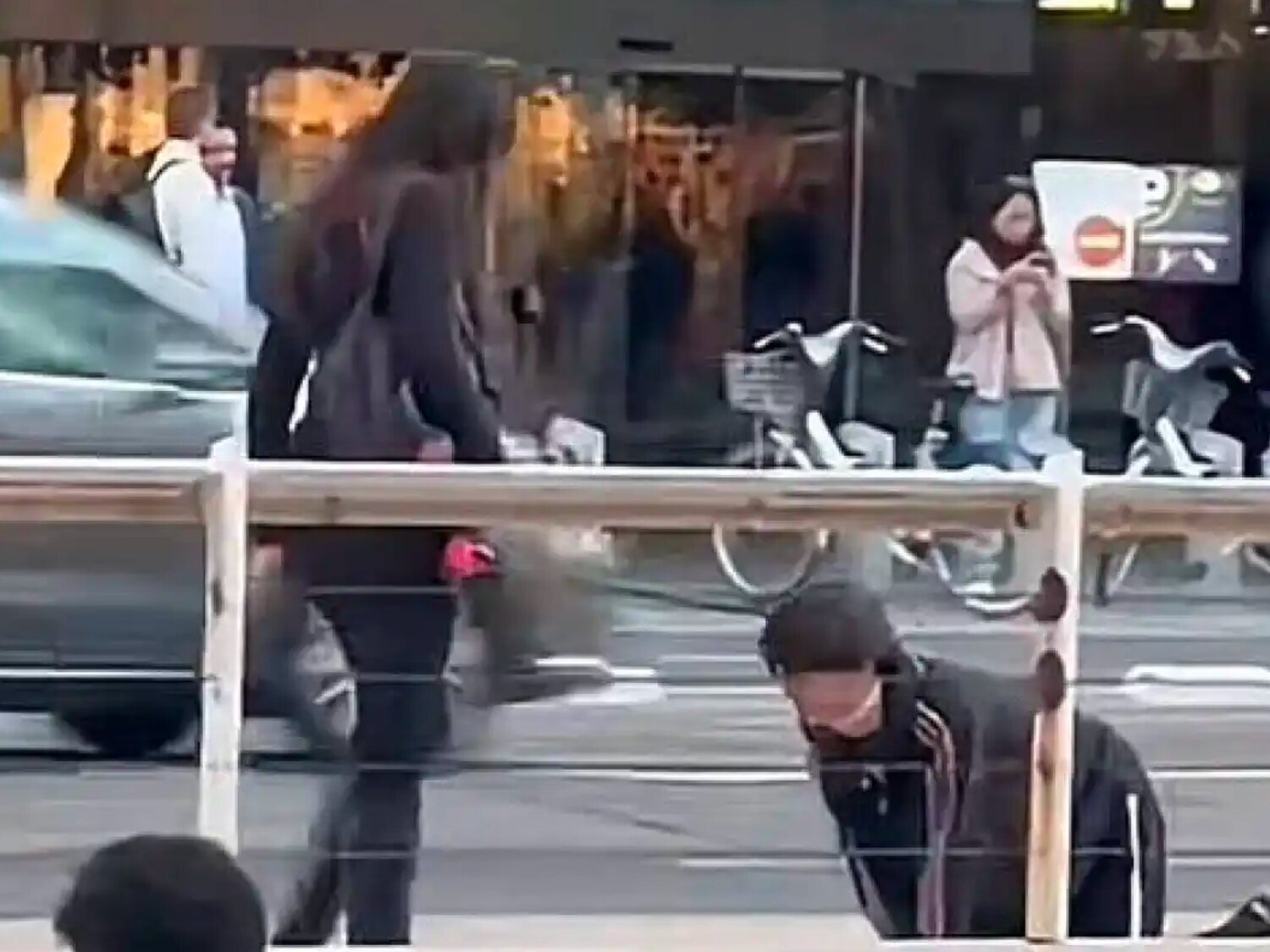Una mujer pasea a un hombre con correa como si fuese un perro por las calles de Valencia
