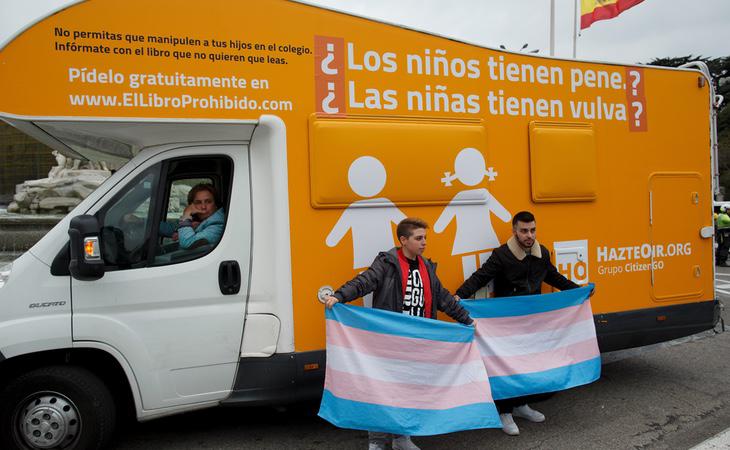 Dos activistas ante la caravana transfóbica de Hazte Oír