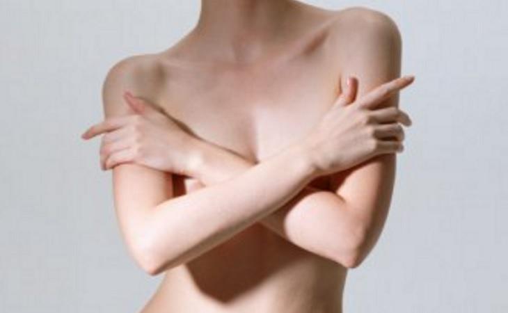 Una persona desnuda tapando parte de su cuerpo con sus brazos