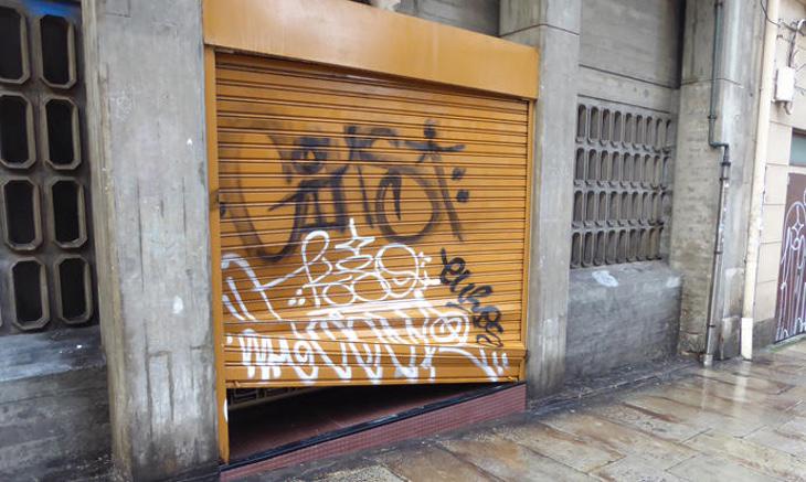 La puerta del garaje de la residencia tras ser golpeada por los jóvenes