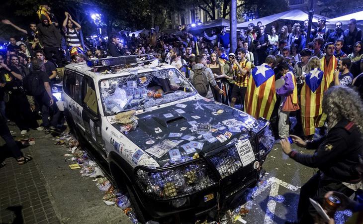 Manifestantes 'pacíficos' destrozan un coche de la Guardia Civil mientras intentan evitar su trabajo