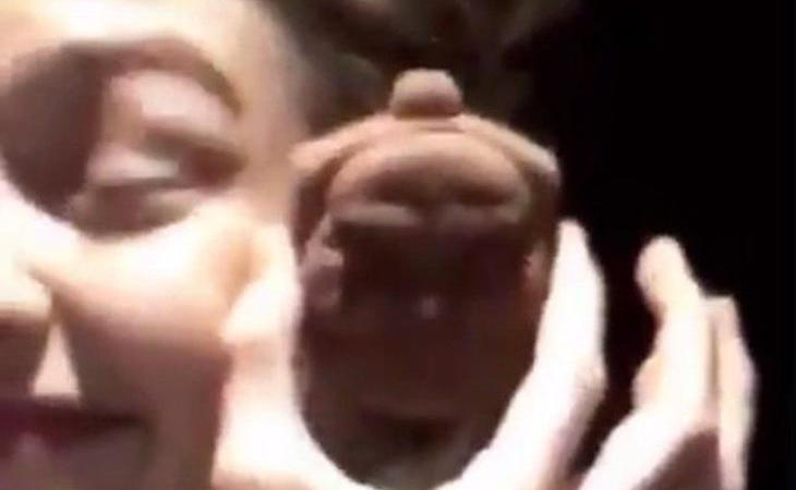Captura del vídeo en que Gigi aparece 'achinando' los ojos junto a una figura de Buda