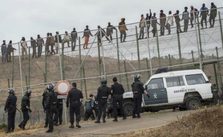 Migrantes en la valla de Melilla ante el cordón de la Guardia Civil