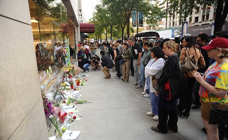 Personas colocando ramos en una tienda de Apple tras la muerte Jobs