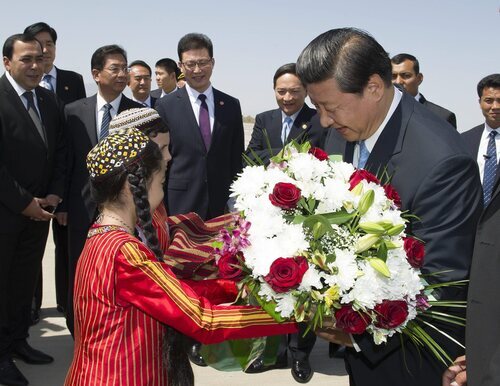 Las mujeres son obligadas a portar el pelo largo con dos coletas en trenzas:  en imagen, dos niños entregan flores al presidente chino, Xi Jinping