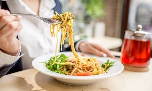 Persona comiendo un plato de pasta