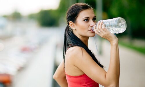 Chica bebiendo agua para hidratarse