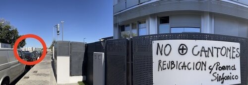 Cartel contra los cantones en la fachada de una vivienda y, al fondo, cantón de basuras