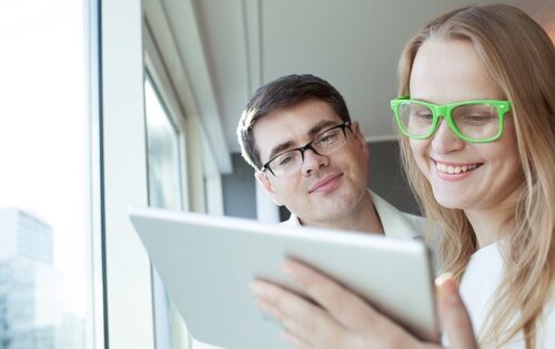 Chico y chica utilizando gafas para ver una tablet