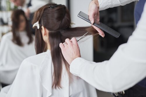 Mujer cortándose el pelo en la peluquería