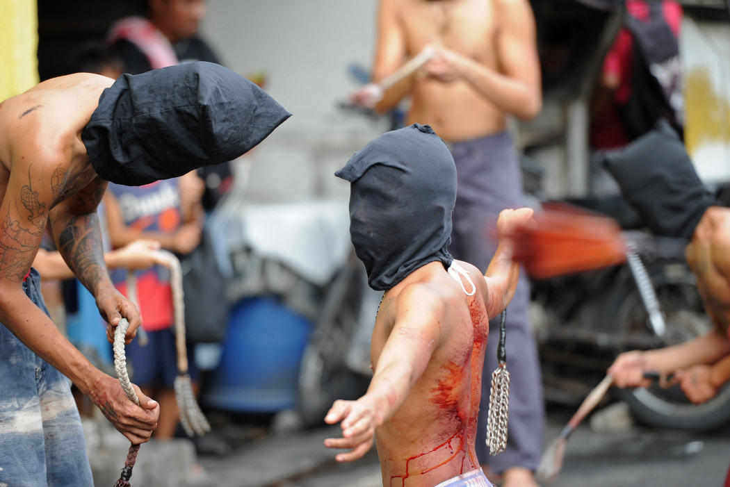 Los penitentes filipinos se flagelan durante la Semana Santa