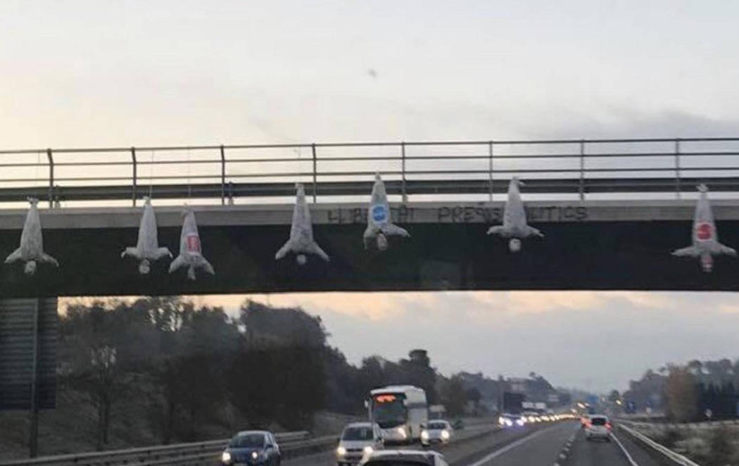 Cuelgan muñecos de un puente de Barcelona con los logos de Ciudadanos, PSC y PP