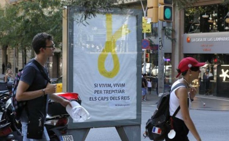 Polémico cartel en Barcelona con una soga amarilla: "Si vivimos, vivimos para pisar las cabezas de los reyes"