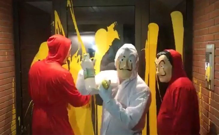 Voluntarios limpian la pintura amarilla de la casa del juez Llarena con caretas de Dalí
