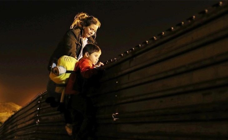 Una madre ayuda a su hijo a cruzar la frontera con EEUU