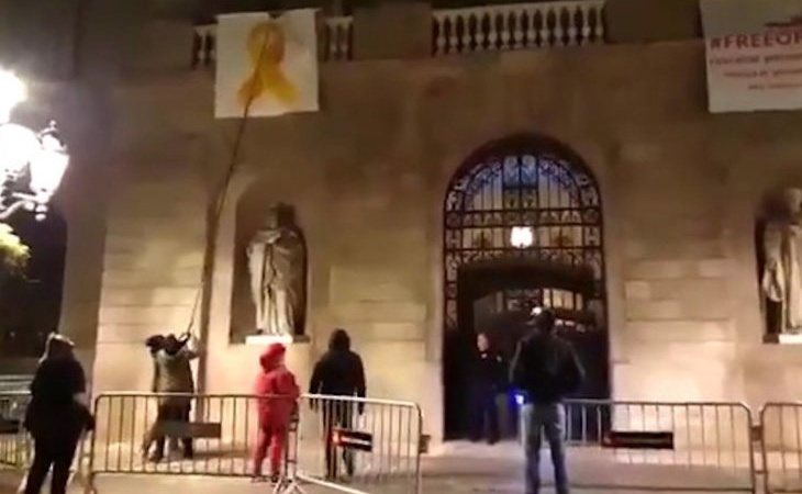Un grupo de activistas encapuchados retiran el lazo amarillo del Ayuntamiento de Barcelona