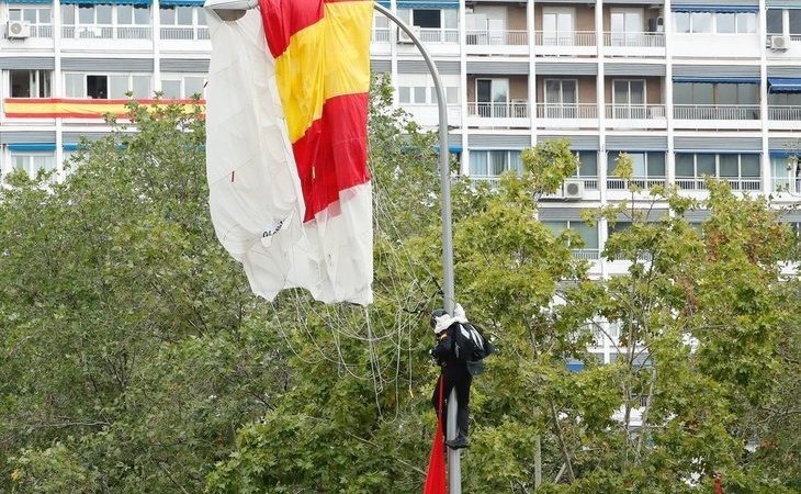 Un paracaidista se estampa con una farola en el desfile del Día de la Hispanidad