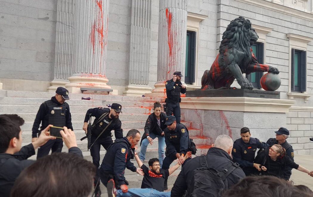 Activistas climáticos lanzan pintura roja contra los leones del Congreso