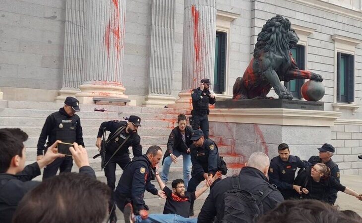 Activistas climáticos lanzan pintura roja contra los leones del Congreso