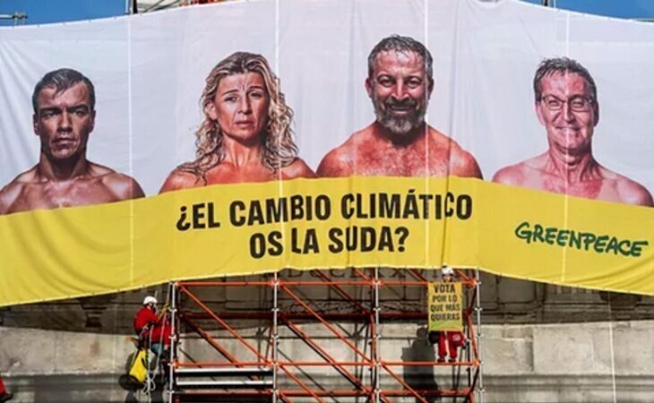 Greenpeace cuelga una lona en la Puerta de Alcalá de Madrid con los principales candidatos: '¿El cambio climático os la suda?'