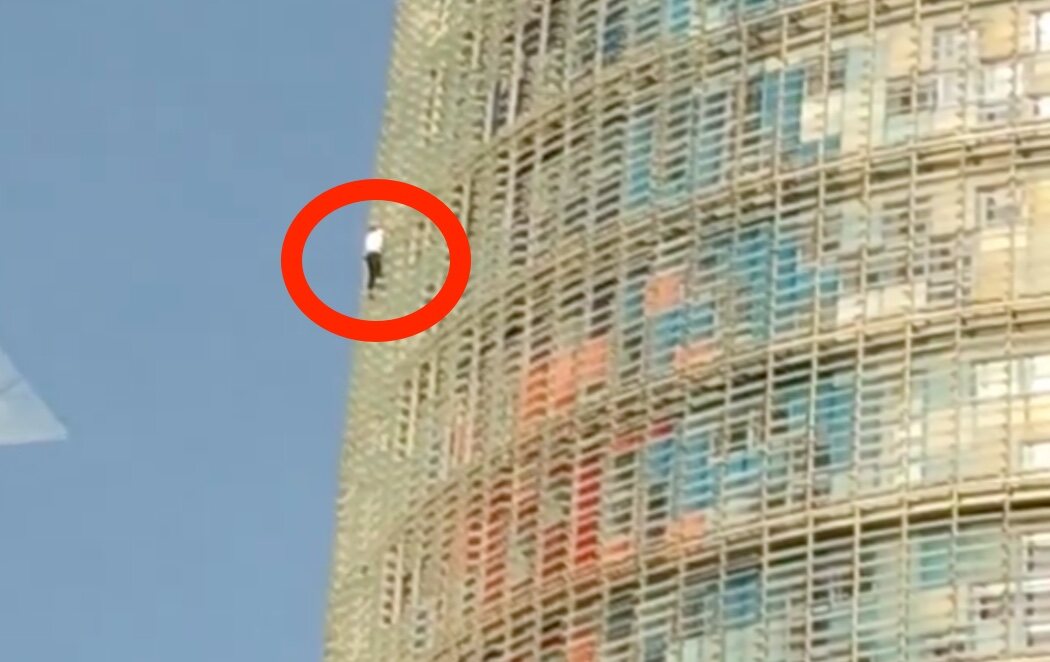 Un hombre desafía a la gravedad y escala la Torre Glòries de Barcelona por la cristalera y sin protección