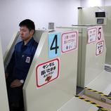 Un trabajador pasa por el escáner de radiación al terminar su jornada laboral