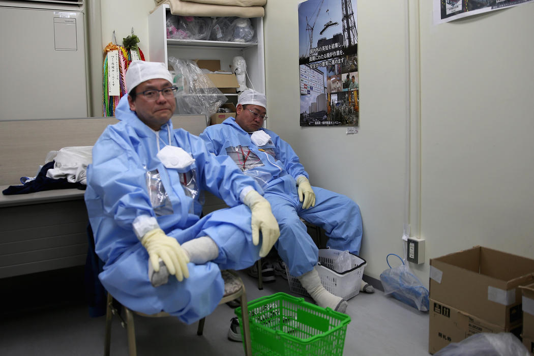 Los trabajadores descansan en su traje protector