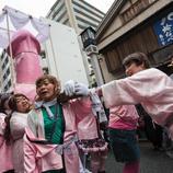 Un grupo de travestis llevan un paso con un enorme falo rosa en su interior