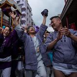 Un grupo de personas cantan y bailan alrededor del mikoshi