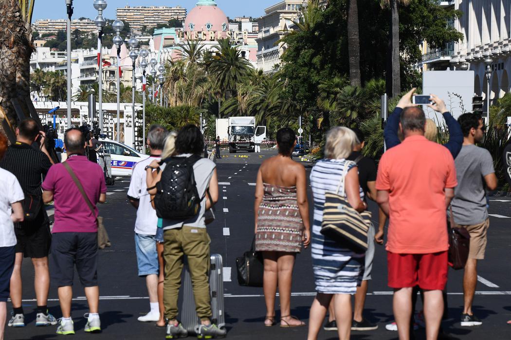 Las personas se agolpan para ver a lo lejos del camión del atentado