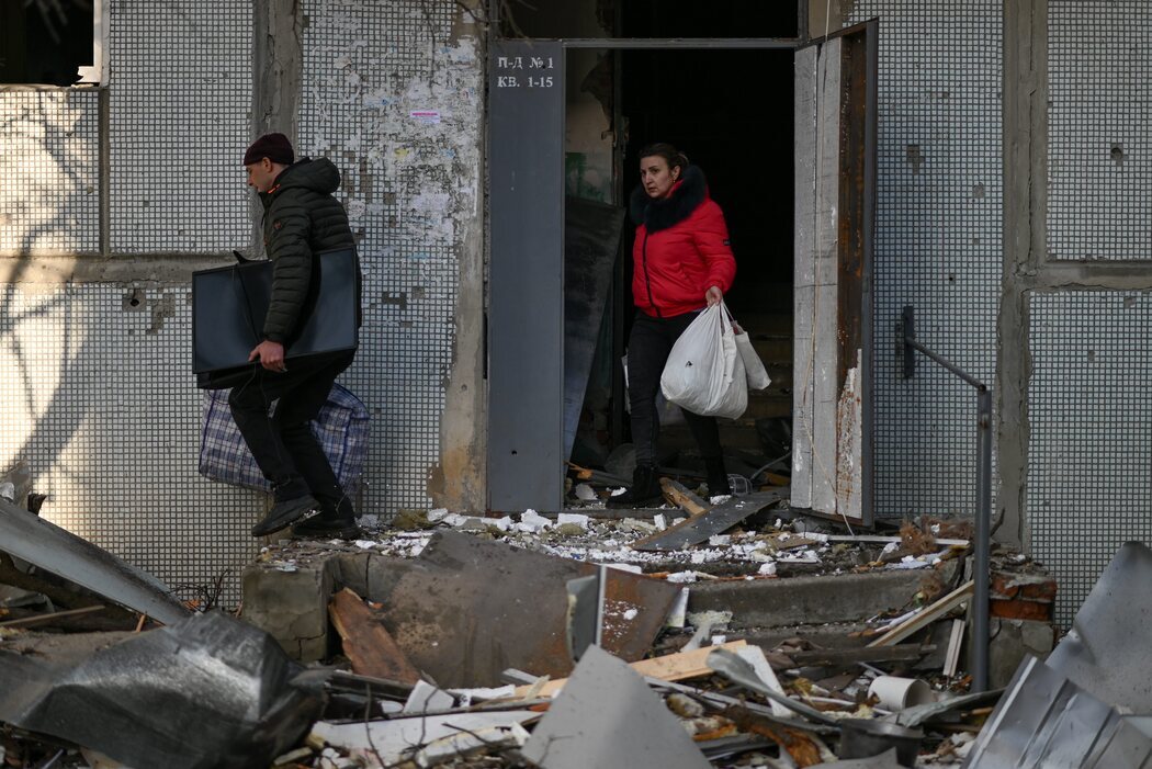 Vecinos de Chugúyev evacuan con sus pertenencias un edificio residencial tras el bombardeo ruso