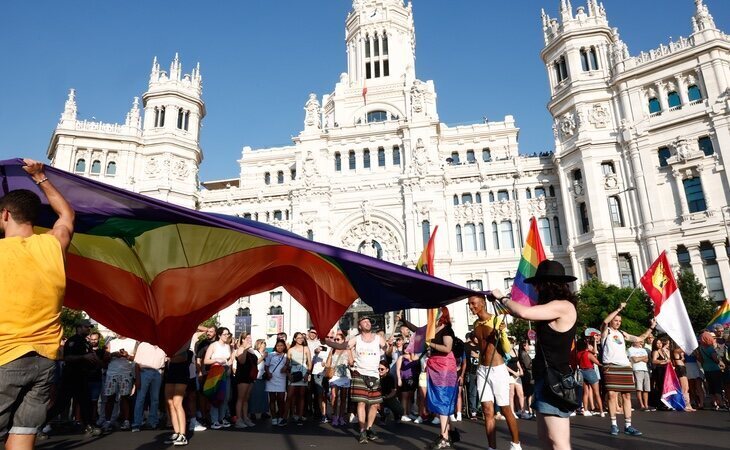Un grupo de manifestantes sitúan la bandera LGTBIQ+ frente al Ayuntamiento