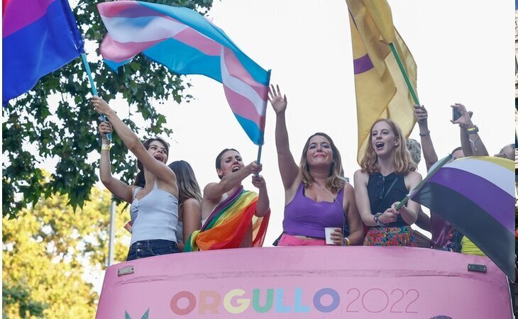 Irene Montero, vestida de la enseña arcoíris, ondea la bandera trans sobre una carroza del Orgullo LGTBIQ+ de Madrid